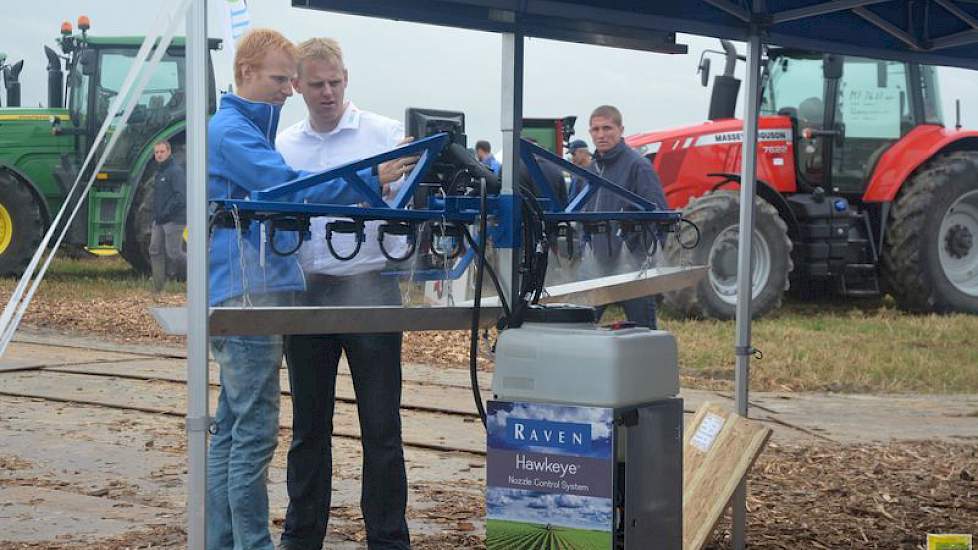 Een teler krijgt uitleg over de Hawkeye spuitregeling, waarbij de dosering per dop wordt geregeld door een pulserende klep.