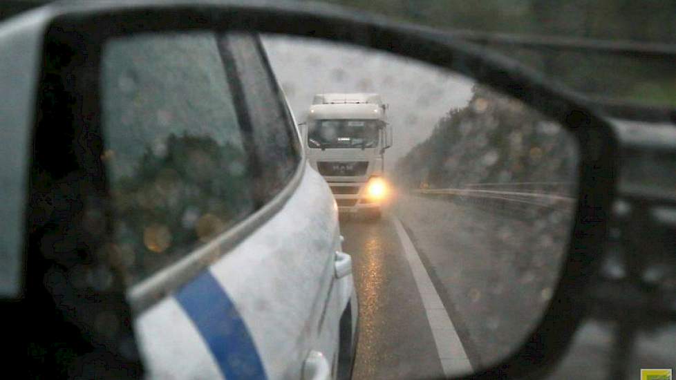 De inspecteur gaat voor de vrachtauto rijden.