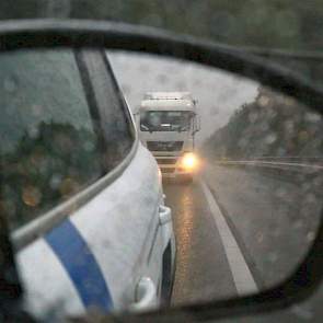 De inspecteur gaat voor de vrachtauto rijden.