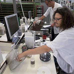 Een ander deel van de eerste bepaling van de samenstelling van het grondmonster gebeurt door medewerkers aan de labtafels.