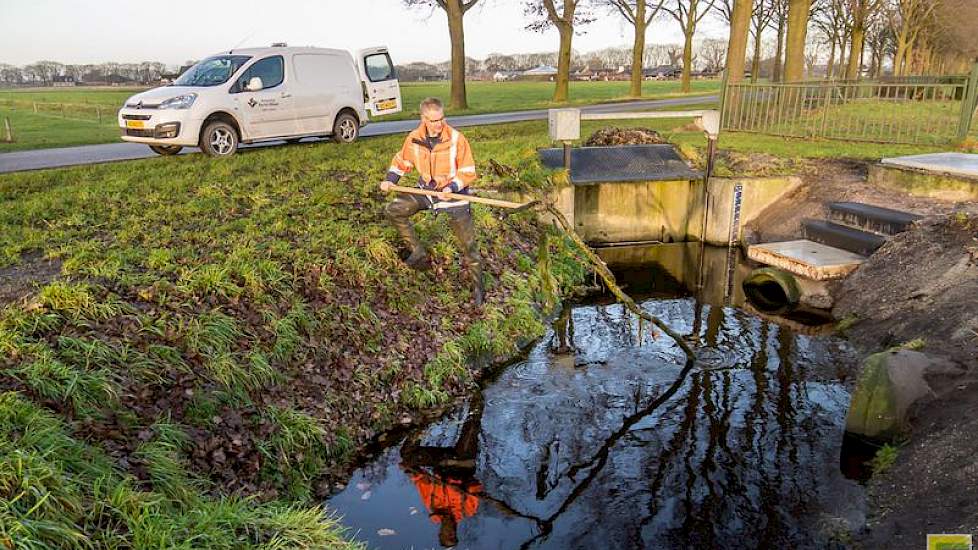 Bij de stuw aan de Lupineweg verwijdert Boom ook meteen een flinke tak die overdwars in de waterloop de doorgang verspert.