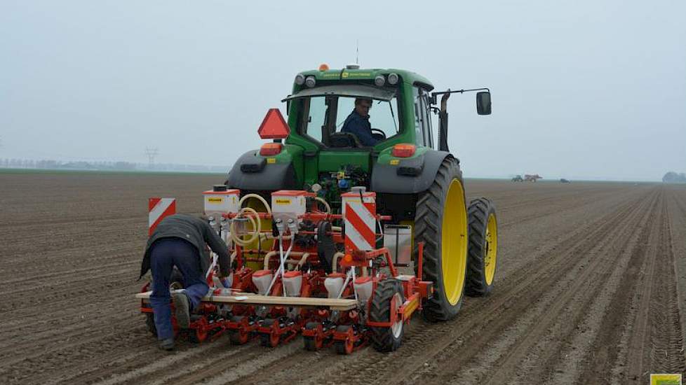 Thijs loopt mee tijdens het zaaien. Af en toe springt hij achterop de machine om iets bij te stellen of een slippend wieltje los te maken.