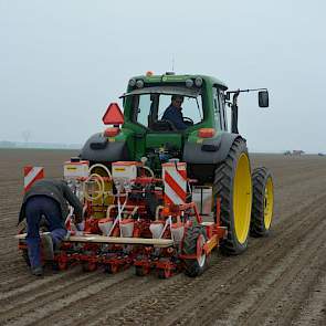 Thijs loopt mee tijdens het zaaien. Af en toe springt hij achterop de machine om iets bij te stellen of een slippend wieltje los te maken.