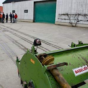 Op de betonnen vloer is  goed zichtbaar hoe de meststof aan beide kanten van vier aardappelruggen wordt gespoten.