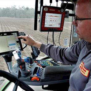 John Peters in de cockpit van de Fendt 516, vol met knoppen, schakelaars en schermen.