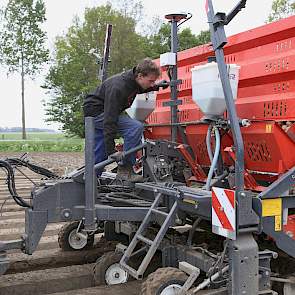 Niels Ottink controleert de instellingen van de pootmachine. Omdat de samenwerking in totaal zo'n 70 hectare pootgoed teelt, zetten ze een snarenbedpootmachine in.