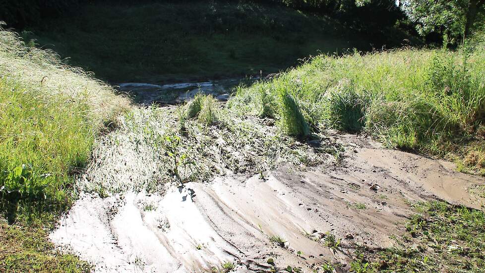 Een aanpalende regenwaterbuffer toonde duidelijk haar nut. Ze ving de modderstroom van het uienperceel op.