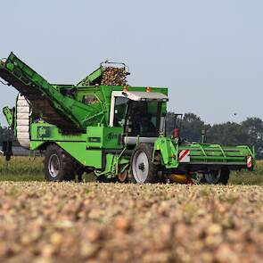 De Drentse akkerbouwer laadt met zijn eigen, (aangepaste) AVR aardappelrooier.