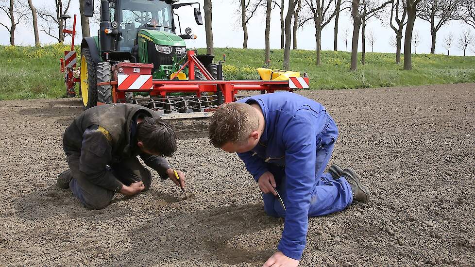 Twee mannen van importeur en dealer ZHE Maasdam zijn op het land voor de fijnafstelling van de zaaimachine.