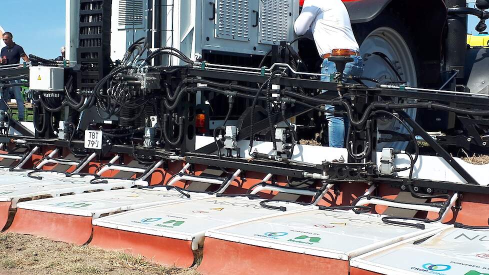 Nucrop timmert aan de weg met elektrische loofdoding. Voorop de trekker zit een spuitboom die een geleidende vloeistof op het loof verspuit. Achterop hangt een installatie die stroom opwekt en deze via flappen en stroombuisjes door het loof laat gaan. Dat