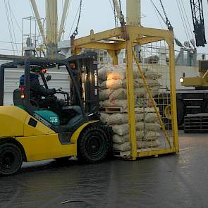 De heftruck plaatst steeds twee pallets met zakken pootgoed in de laadbak…