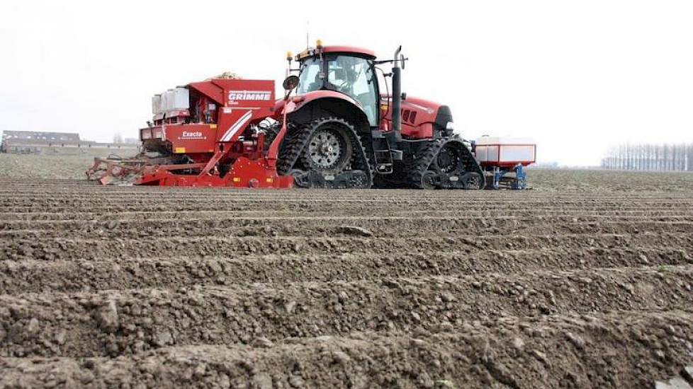 De trekker van maatschap De Nood is op rupsbanden gezet om de druk te verdelen. Voorop zijn bakken gemonteerd waarin de vloeibare fosfaat zit die meegegeven wordt. Achterop de Grimme- planter staan granulaatbakken.