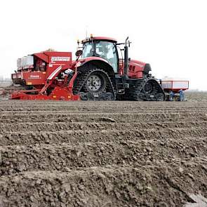 De trekker van maatschap De Nood is op rupsbanden gezet om de druk te verdelen. Voorop zijn bakken gemonteerd waarin de vloeibare fosfaat zit die meegegeven wordt. Achterop de Grimme- planter staan granulaatbakken.